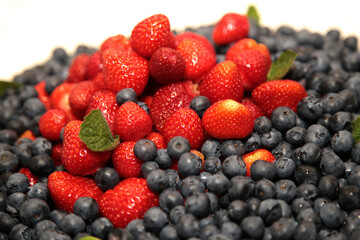 Blueberries with strawberries and mint leaves.