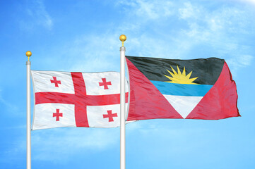 Georgia and Antigua and Barbuda two flags on flagpoles and blue sky