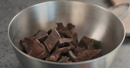 put cocolate crumbs in steel bowl closeup