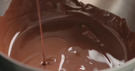 mixing dark melted chocolate with spoon closeup