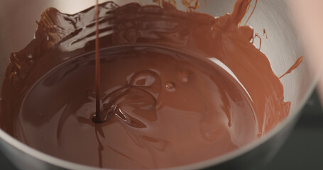 mixing dark melted chocolate with spoon closeup