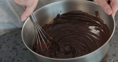 whisking cream with chocolarte in steel bowl