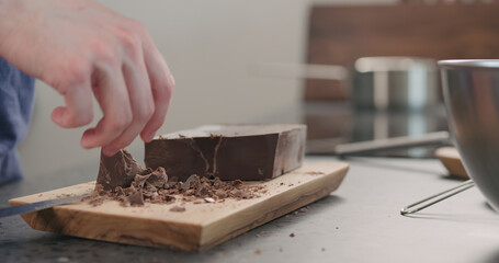 young man take chocolate chunks from board and put in bowl
