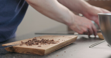 young man take chocolate chunks from board and put in bowl