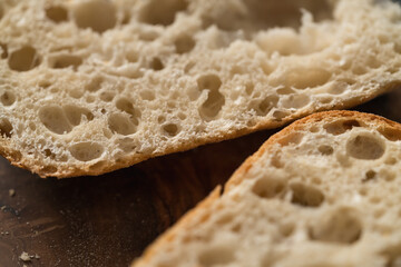 ciabatta bread sliced in half for sandwich on olive board