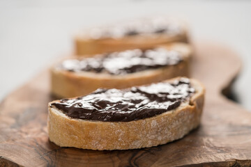 Rustic ciabatta with organic chocolate cream on olive wood board