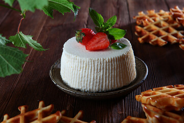 Soft ricotta cheese with strawberries, Basil leaves and waffles on a black background. The concept of a healthy Breakfast. Natural biological products. Copy of the space.Top view.