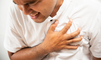 A man has heart disease. hand in the chest, squeezing his heart he had a sudden heart attack. Symptom hurt ache sore pain.