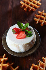 Soft ricotta cheese with strawberries, Basil leaves and waffles on a dark background. The concept of a healthy Breakfast. Natural biological products. Copy of the space. Vertical photo.Top view.