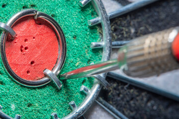 Blurred in soft focus at high magnification, an abstraction background with part of an old dart board with a close-up of the dart hit very close to the center. Concept - an attempt to achieve success