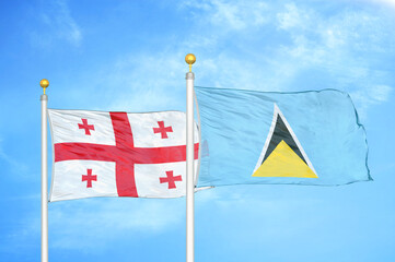 Georgia and Saint Lucia two flags on flagpoles and blue sky