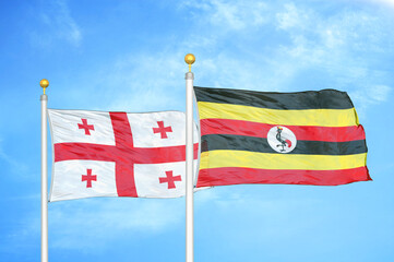 Georgia and Uganda two flags on flagpoles and blue sky