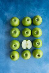Bright green apples on blue background.