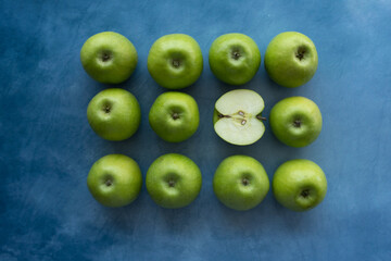 Bright green apples on blue background.