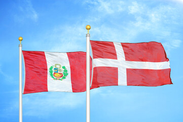 Peru and Denmark two flags on flagpoles and blue sky