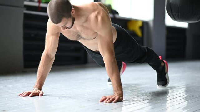  Young muscular athlete doing suspension pushups