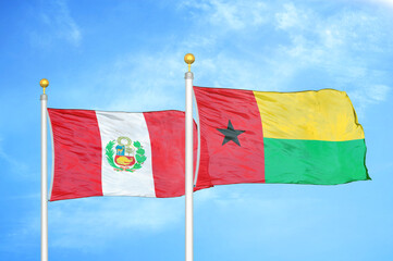 Peru and Guinea-Bissau two flags on flagpoles and blue sky