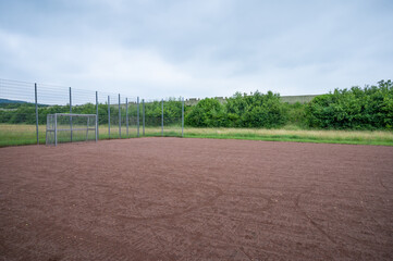 soccer field with metal goal and metal fence for youngsters to play