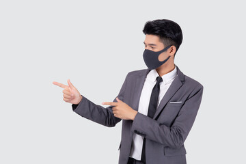 Obraz na płótnie Canvas Portrait young asian businessman in suit wearing face mask for protective covid-19 isolated on white background, business man presenting and showing, quarantine for pandemic coronavirus, new normal.