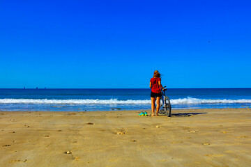 girl on bicyle on beach- freedom and holiday concept