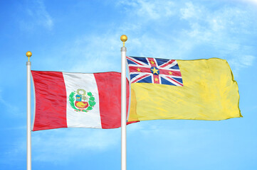 Peru and Niue two flags on flagpoles and blue sky