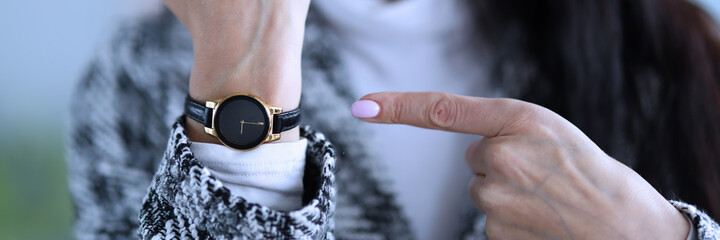 Displeased woman shows time on her wristwatch. Woman analyzes market in global and local senses,...