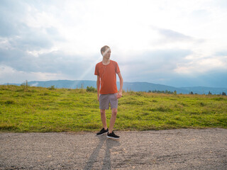 Obraz premium young runner man warms up for running on the hill in nature