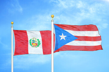 Peru and Puerto Rico two flags on flagpoles and blue sky