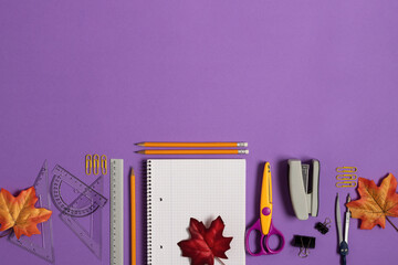 Blank notebook with school and office supplies on purple background top view.