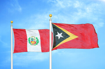 Peru and Timor-Leste East Timor two flags on flagpoles and blue sky