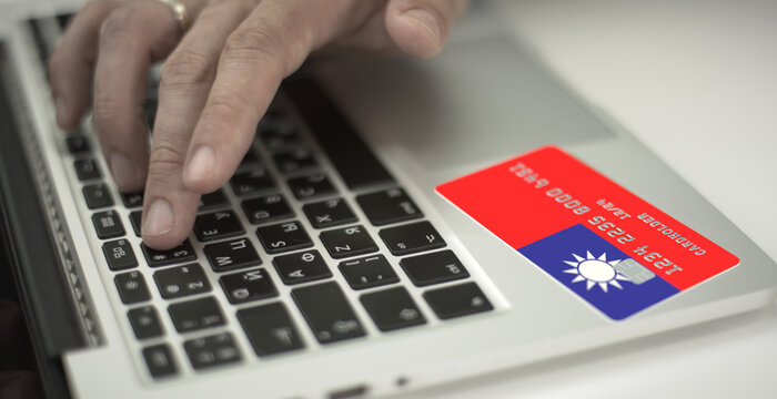 Man pays online with plastic bank card with printed flag of Taiwan. Fictional numbers - Powered by Adobe
