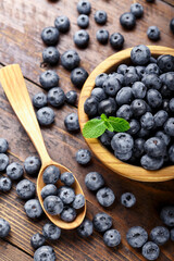 Freshly picked blueberries in wooden bowl on a wooden  table. Healthy fruits.