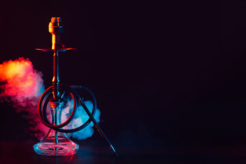 glass hookah shisha with a metal bowl on the table on a black background with smoke - obrazy, fototapety, plakaty