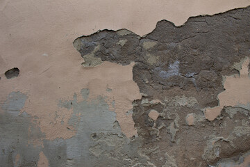 Old dirty weathered wall with layers of plaster falling off ready for repair