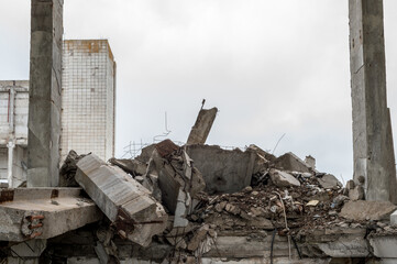 Large grey concrete fragments of a building with a lying beam in the foreground. Background.