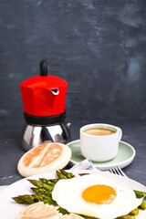 Healthy breakfast. Fried eggs, asparagus, bread and aromatic coffee on a gray background. Free place for text. Soft focus. High quality photo