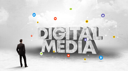 Young businessman standing in front of DIGITAL MEDIA inscription, social media concept