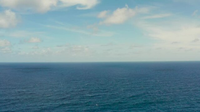 Blue ocean with waves and sky with clouds, seascape top view. Water cloud horizon background. Blue sea water with waves against sky.
