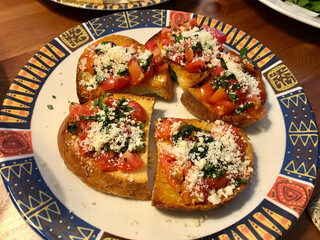 Homemade Tasty Savory Tomato Italian Appetizers, or Bruschetta, on slices of Toasted Baguette