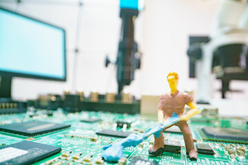 Miniature repair man on mainboard, Miniature figure of worker team try to repair cpu on mainboard.