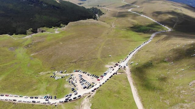 Panoramic aerial view of a long line of cars parked on the side of the road at Piatra Arsa