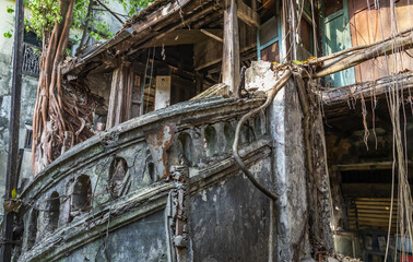 Fototapeta na wymiar Bangkok,Thailand - Jan 25, 2020 : The remains of a derelict abandoned ancient house with antique stone stairs and tree roots. Archaeological area. No focus, specifically.