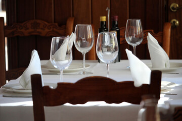 Table set in a restaurant with silverware, wine glasses and napkins