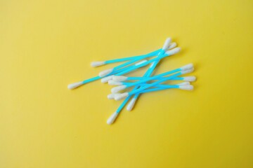 Ear cotton buds are blue on a yellow background. Cosmetology and medicine. Personal hygiene and care.