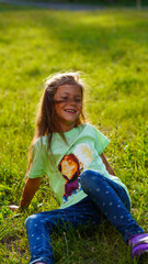 Fototapeta premium Portrait of pretty girl in green shirt in summer park