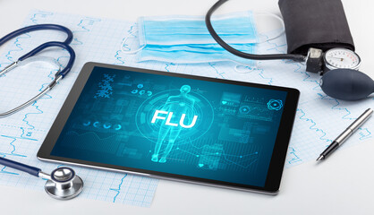 Tablet pc and doctor tools with FLU inscription, coronavirus concept