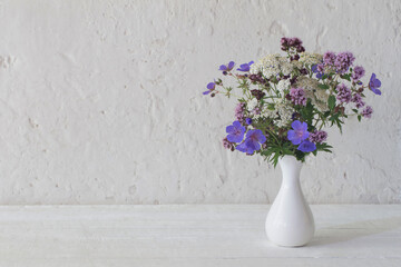wild flowers in white vase on white background