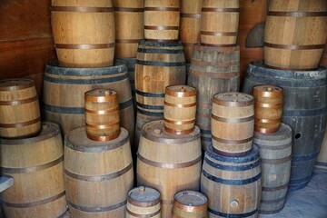 Small and large wooden barrels stacked inside a room