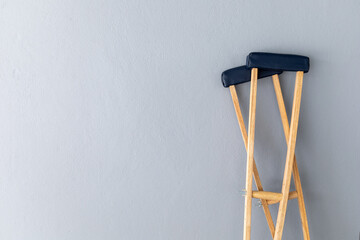 closeup pair wooden crutches on gray background