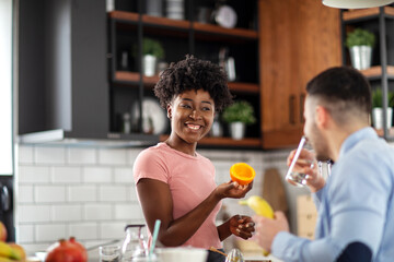 Multiethnic couple in the kitchen preparing healthy smoothie